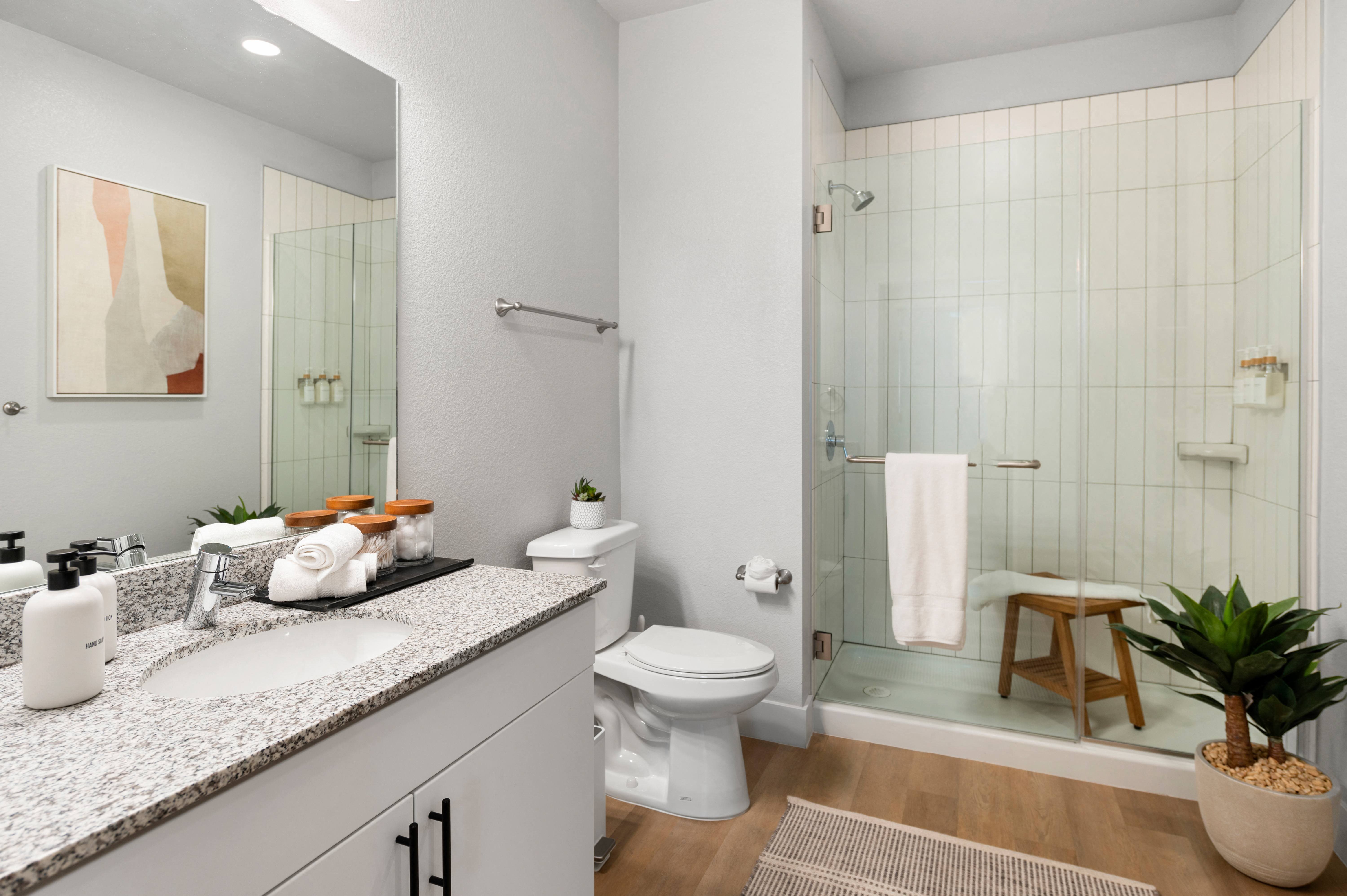 a bathroom with a shower and a toilet and a sink